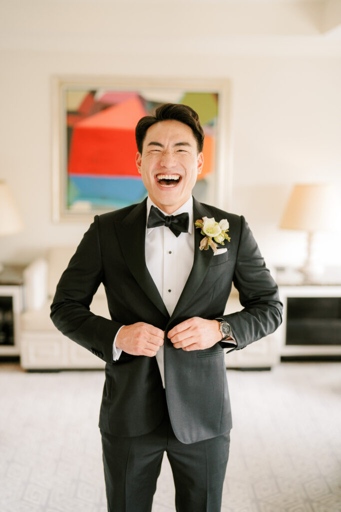 Korean groom in tux laughing at Lotte Palace hotel 