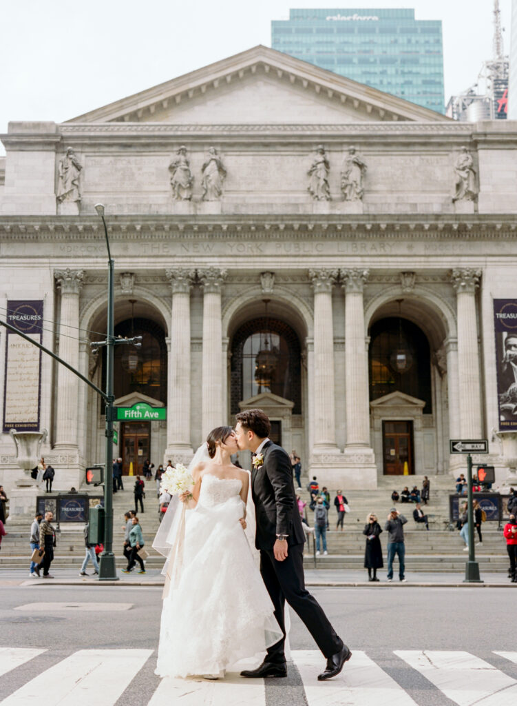 Bride and groom kissing in front of New York Public Library on Fifth Ave