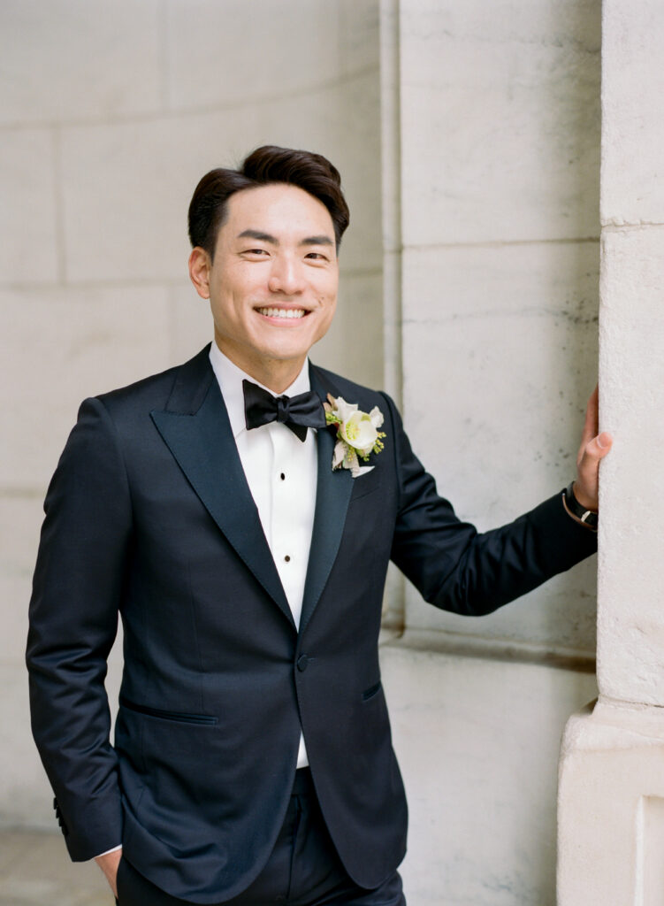 Groom portrait in black tux with white autumn boutonniere 
