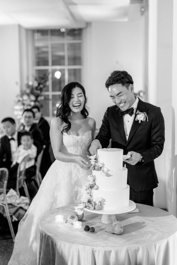 Bride and groom laughing and cutting cake in NYC loft wedding venue