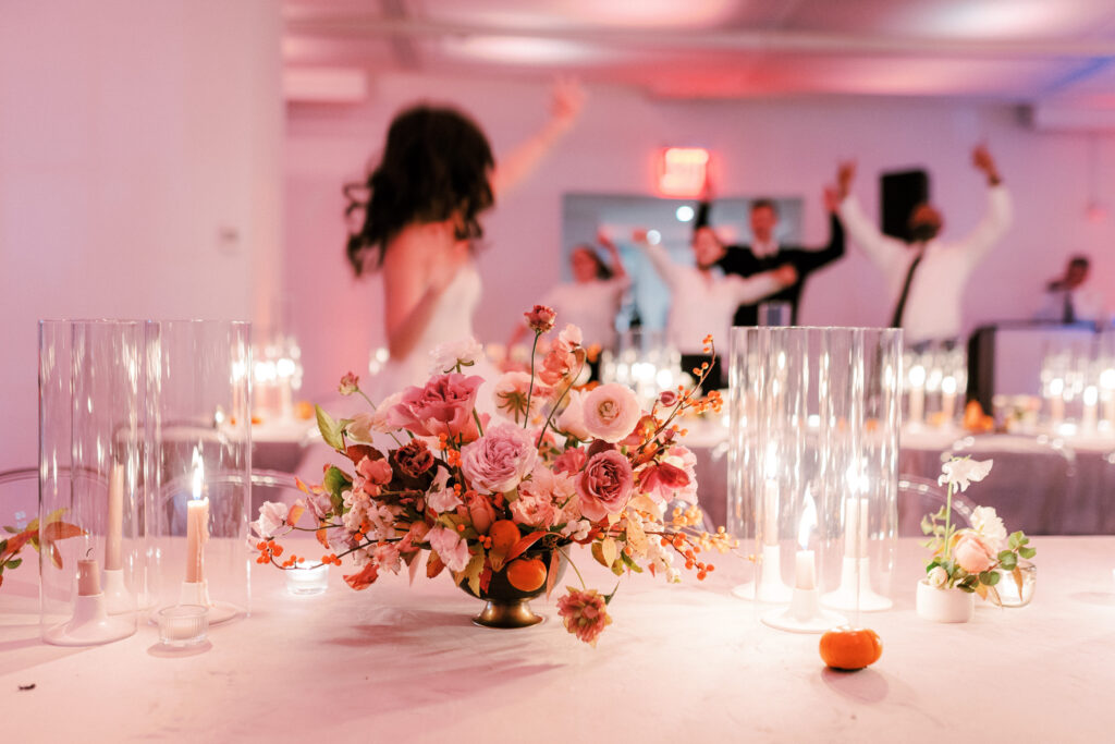Bride dancing in NYC loft wedding venue with lush floral centerpiece autumn wedding 