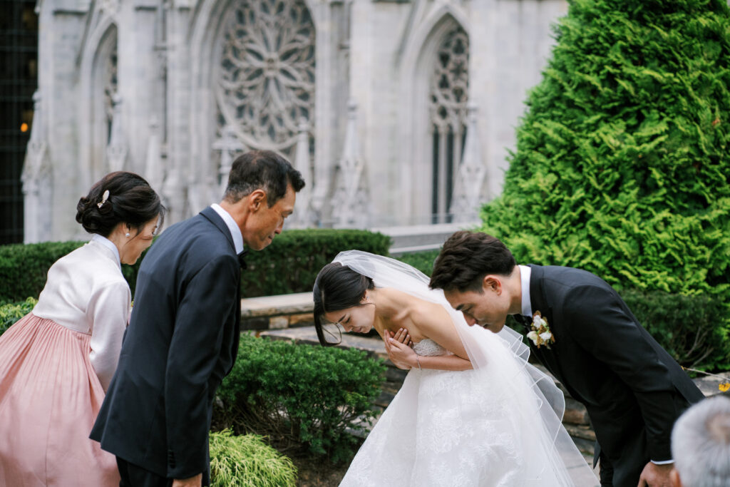 Bride and groom bowing to Korean parents after wedding ceremony 