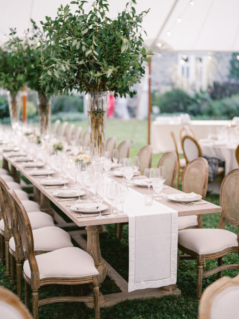 hemstitch linen table runner in white on farm tables with olive branch greenery at outdoor tented wedding in baltimore 