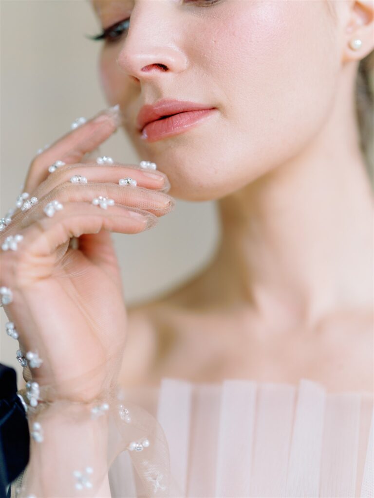 Close up photo of lips of bride and rhinestone glove on hand