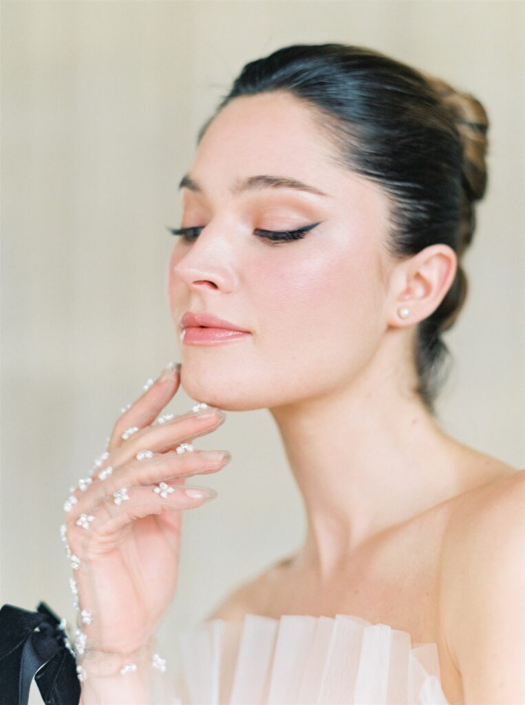 Bridal makeup closeup with winged eyeliner and fresh dewy skin on film 