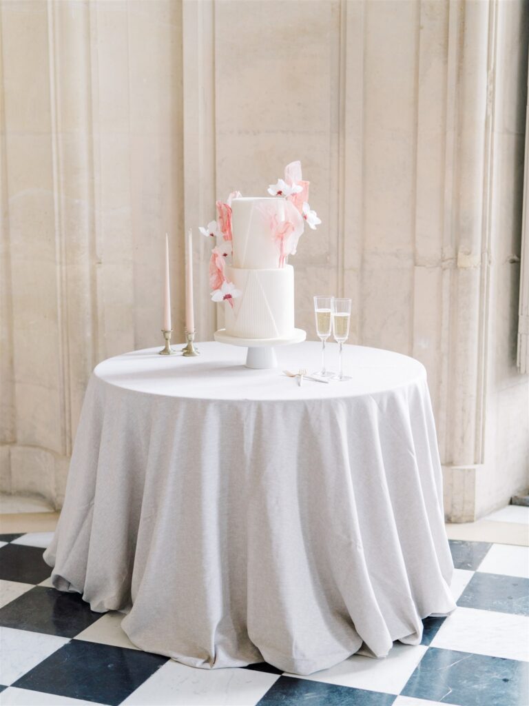 whimsical pink and white wedding cake on table 