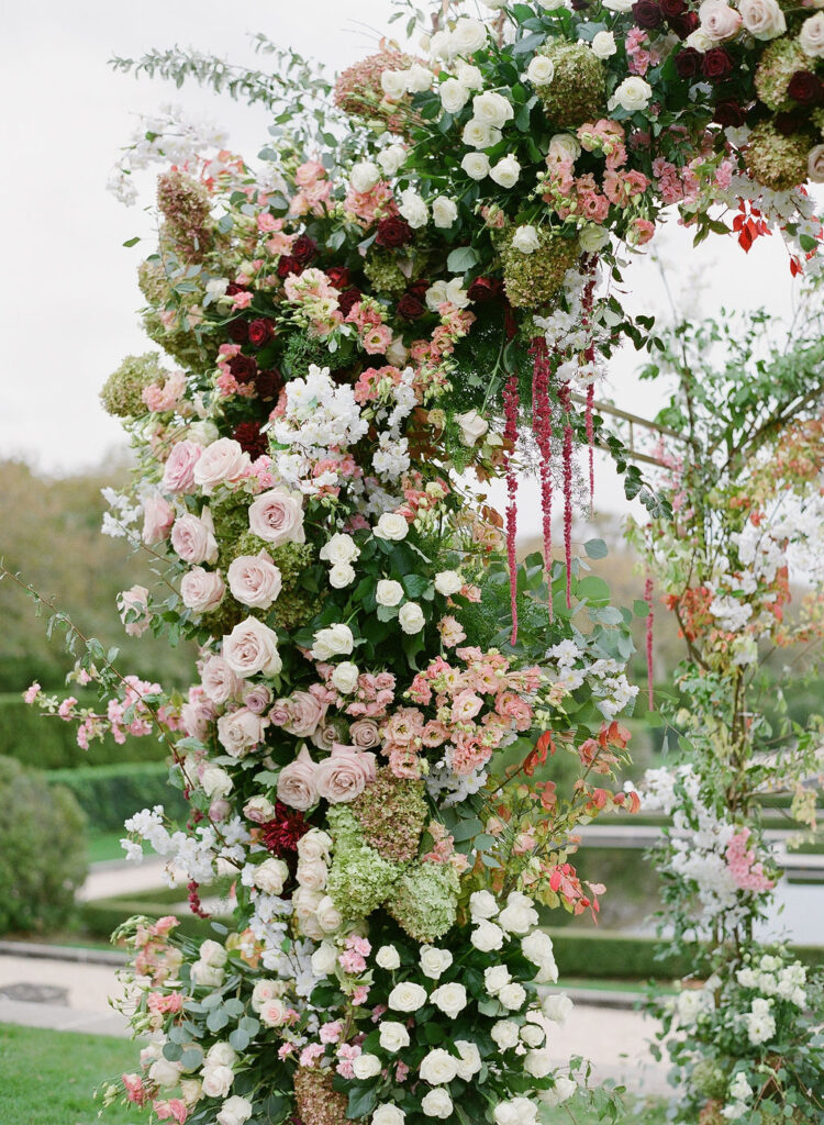 close up of rose floral arch in blush and burgundy wedding 