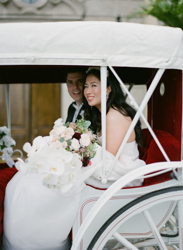 bride smiling in horse-drawn carriage at oheka castle 