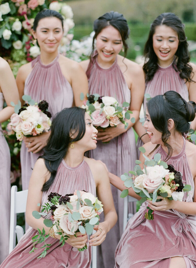 bridesmaids laughing in rose velvet dresses 
