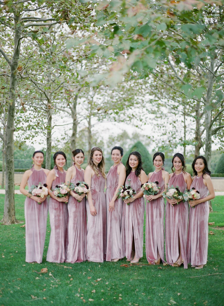 bridesmaids in rose velvet long dresses with blush rose bouquets 