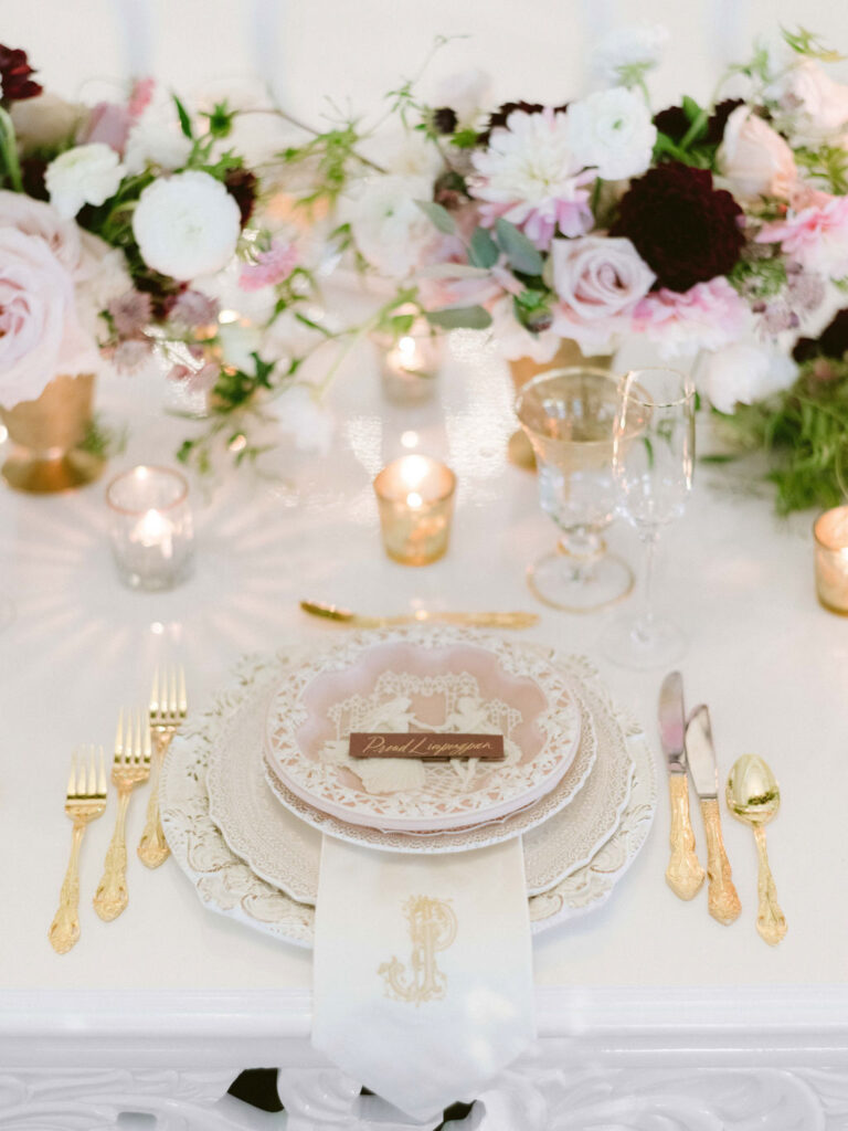 close up of place setting with embellished plates and gold flatware ornate wedding design at luxury wedding venue oheka castle 