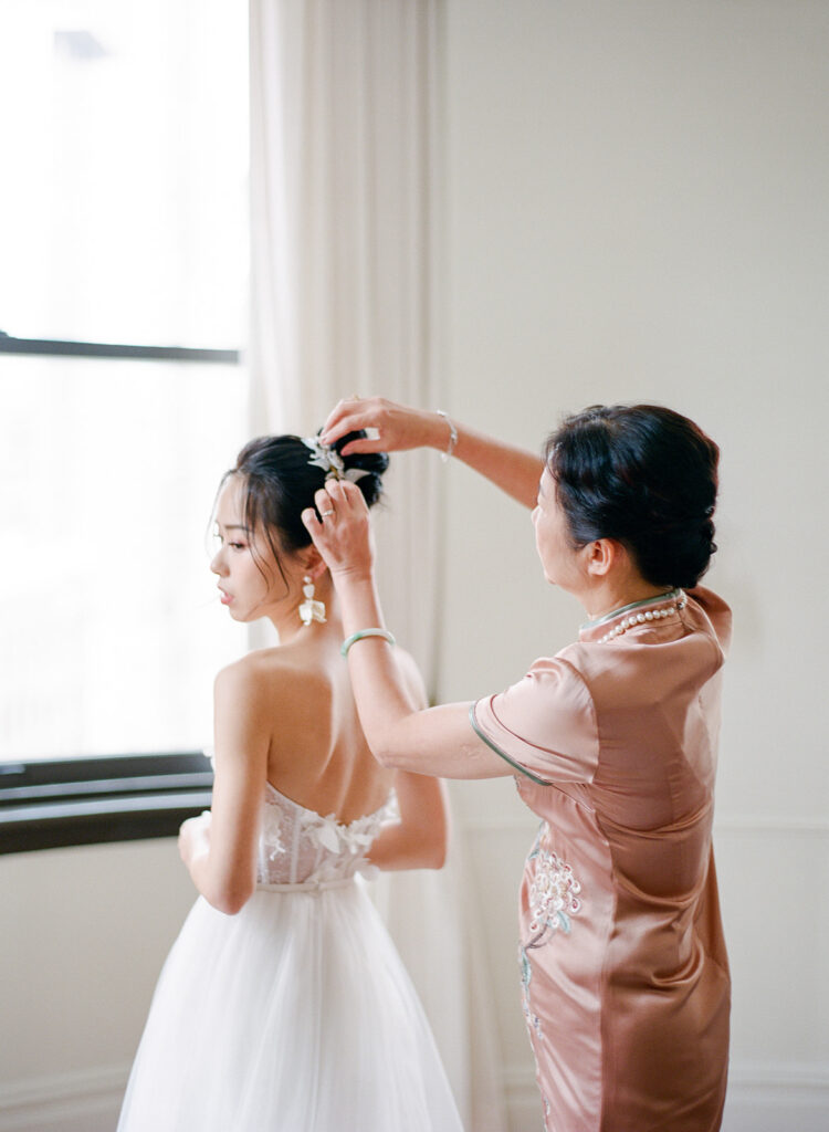 bride and her mom helping fix her hair