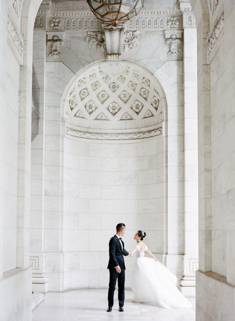 bride and groom twirling at new york public library 