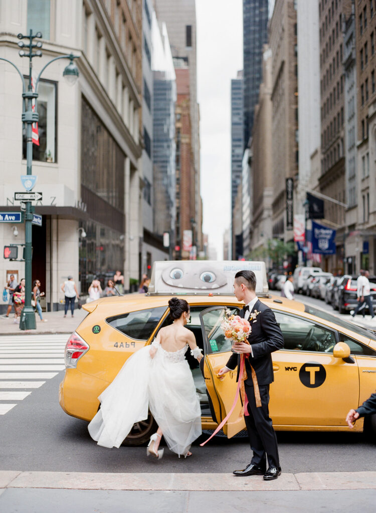 bride and groom getting in yellow taxi cab on fifth ave in manhattan 