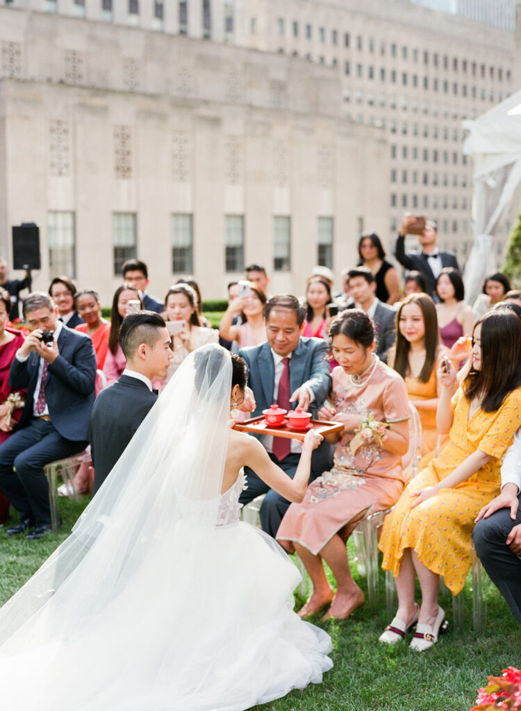 chinese bride and groom at tea ceremony on wedding day outdoors 
