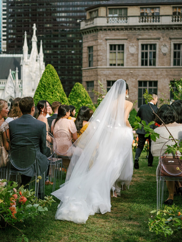 bride running down aisle with long veil at ceremony on nyc rooftop 