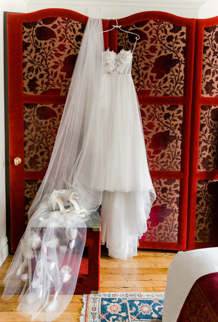 wedding dress, veil, hanging up on red dressing door