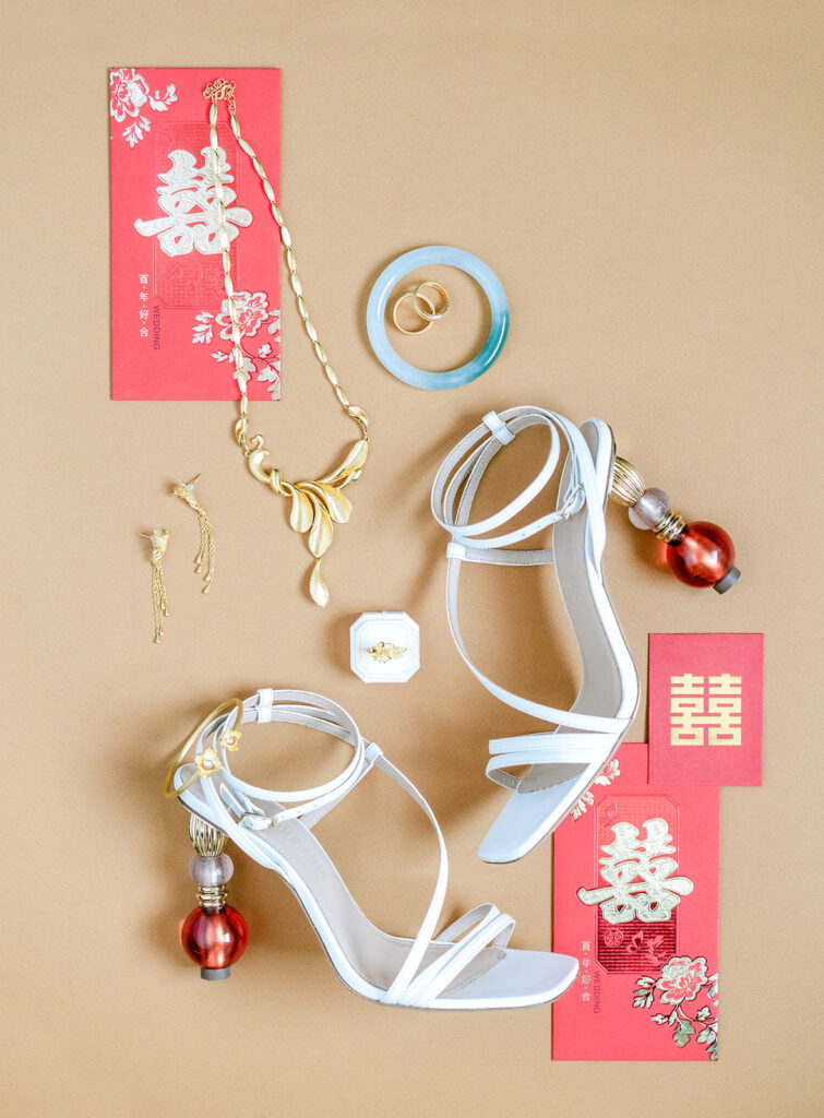 chinese money envelopes and wedding shoes and gold jewelry in flatlay 